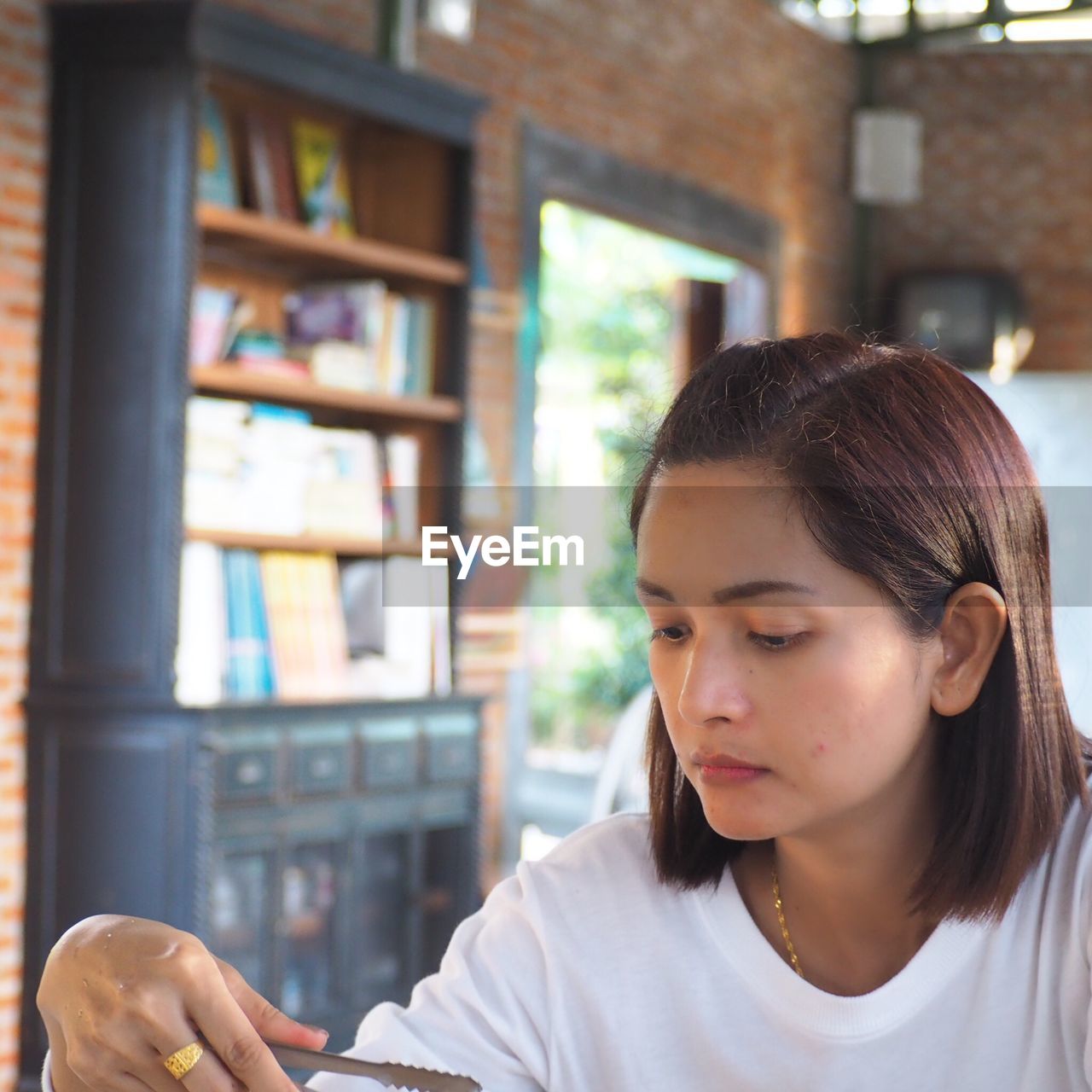 Close-up of woman looking down while holding serving tongs