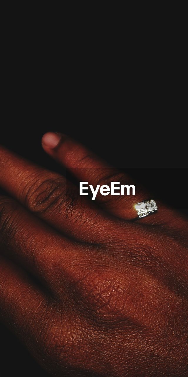 CLOSE-UP OF HUMAN HAND ON FINGER OF BLACK