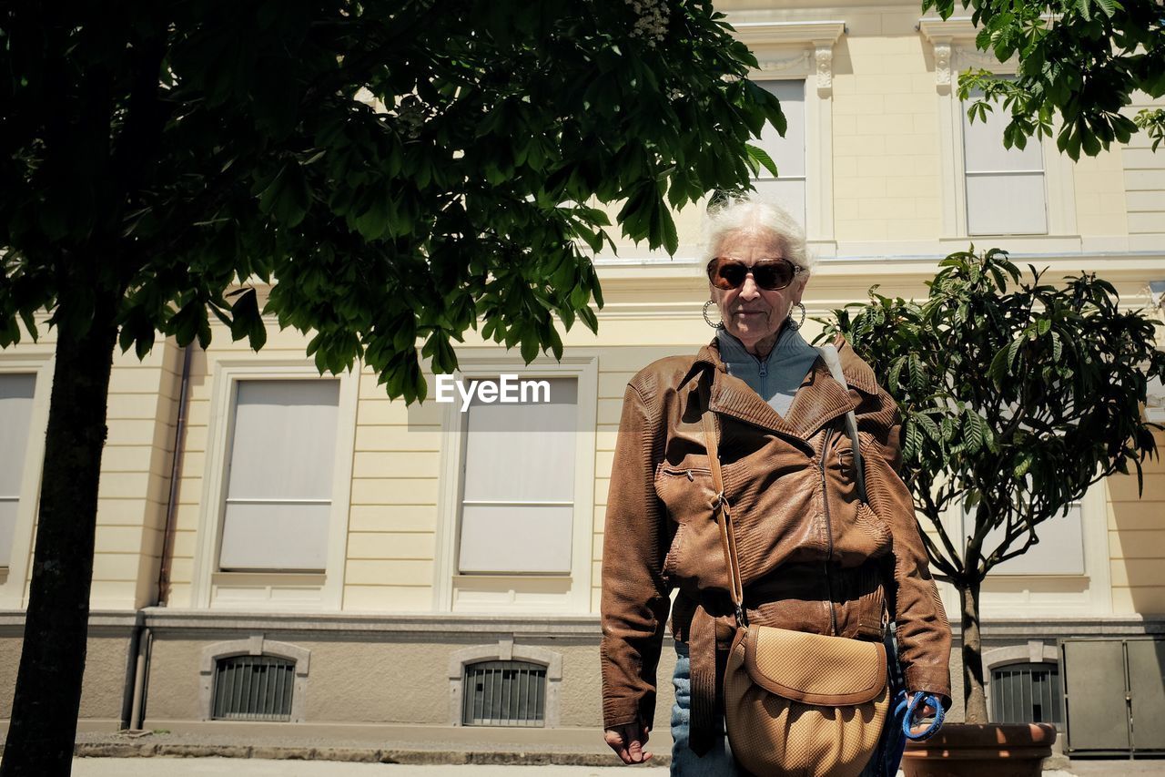 PORTRAIT OF MAN STANDING AGAINST TREE