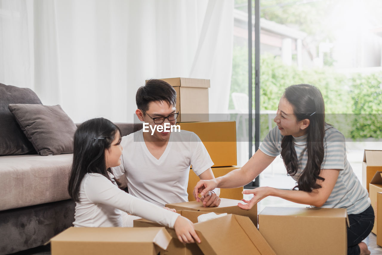 Smiling family packing boxes