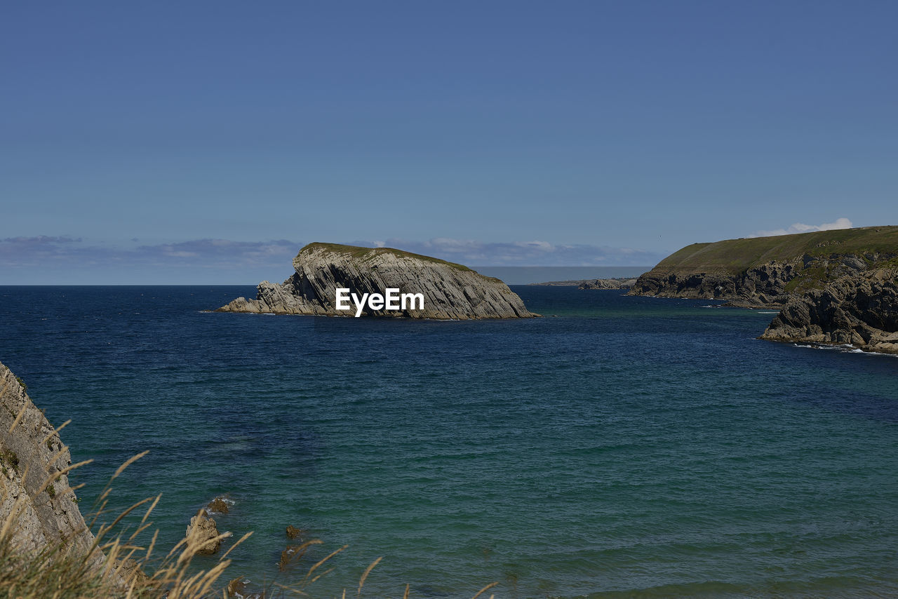 rock formations in sea against clear blue sky