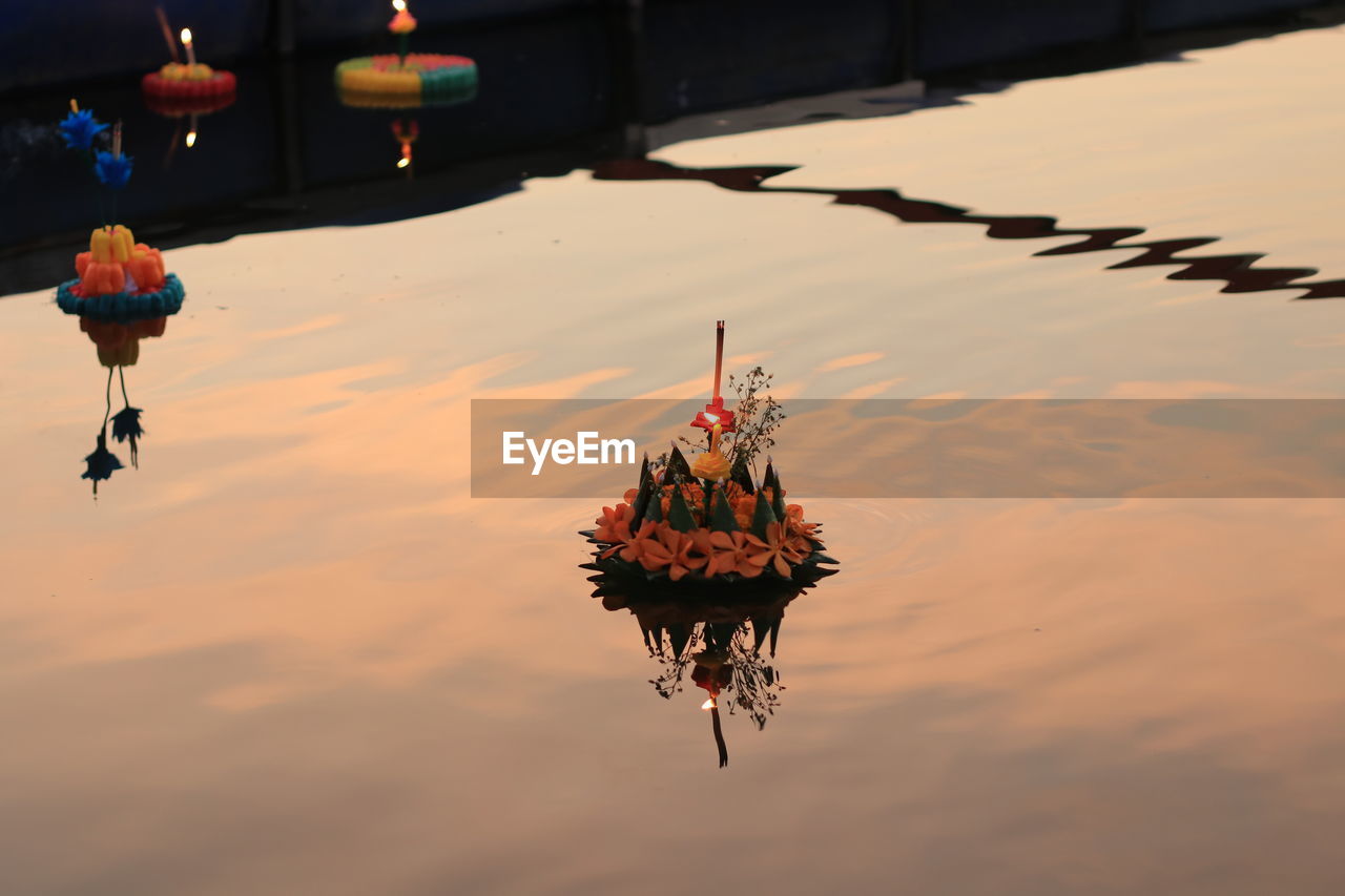 HIGH ANGLE VIEW OF ORANGE FLOATING ON LAKE