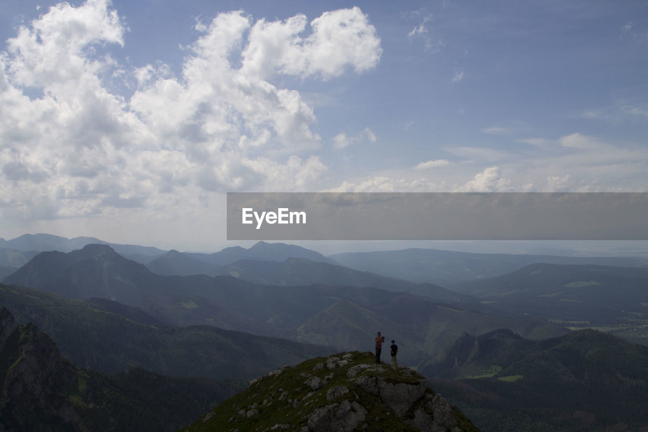 High angle view of people standing on mountain against sky