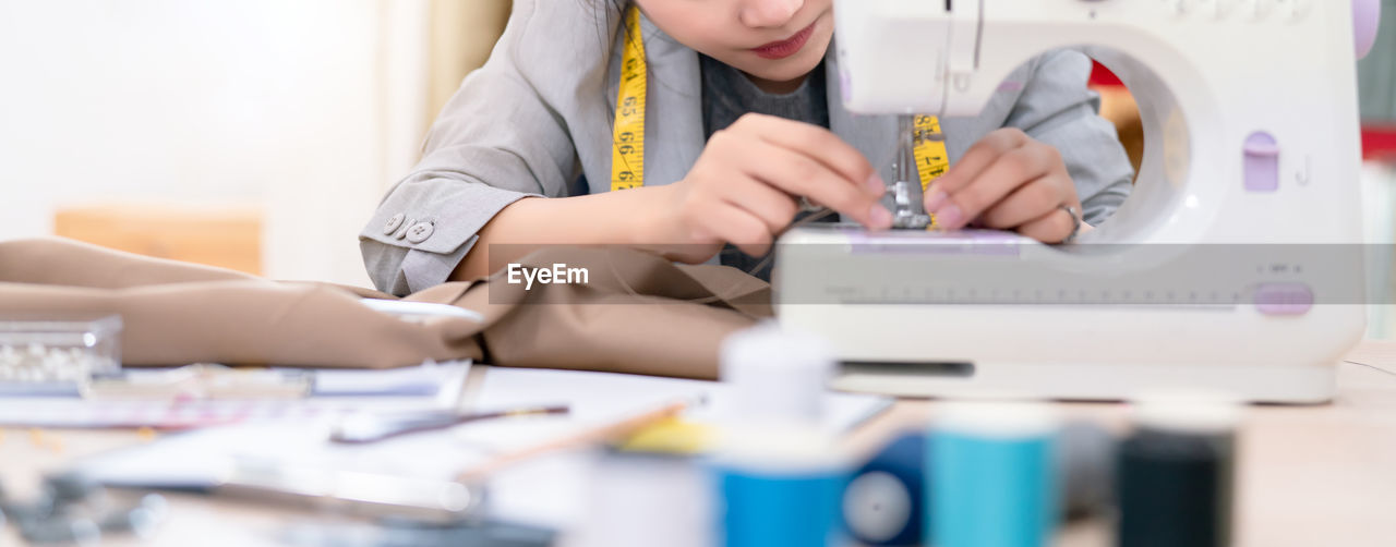 MIDSECTION OF WOMAN WORKING IN WORKSHOP