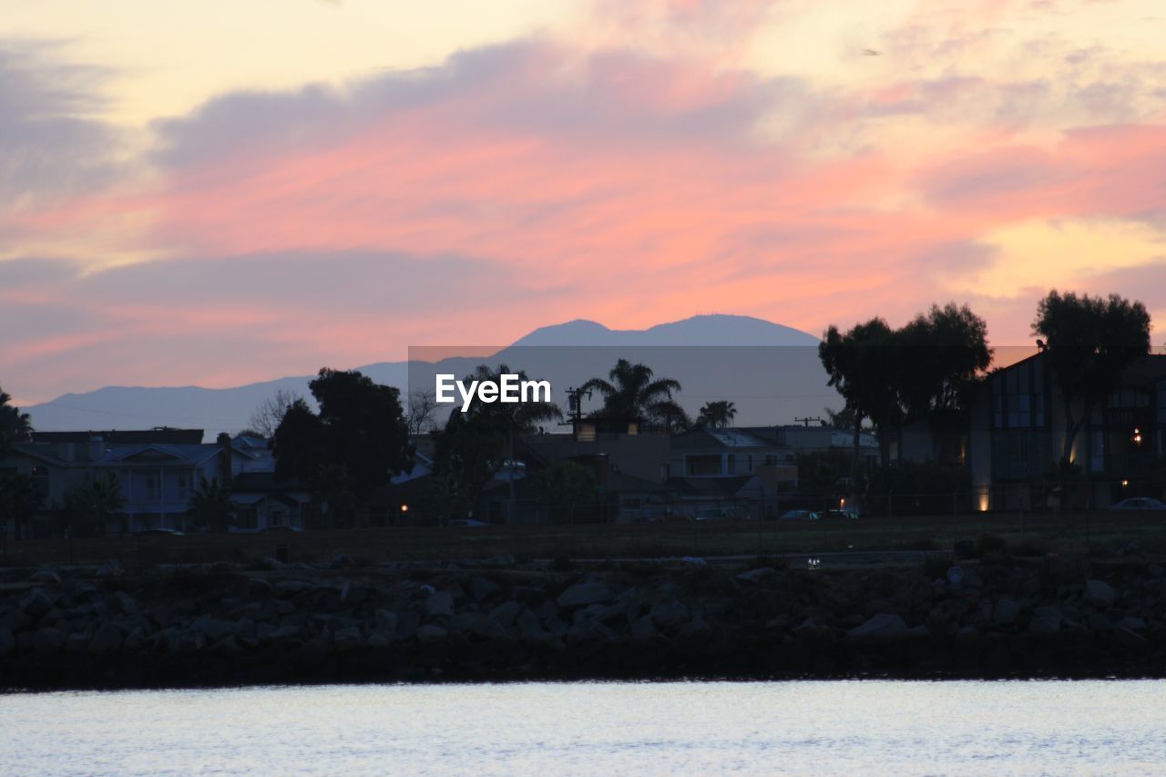 HOUSES AGAINST SKY AT SUNSET