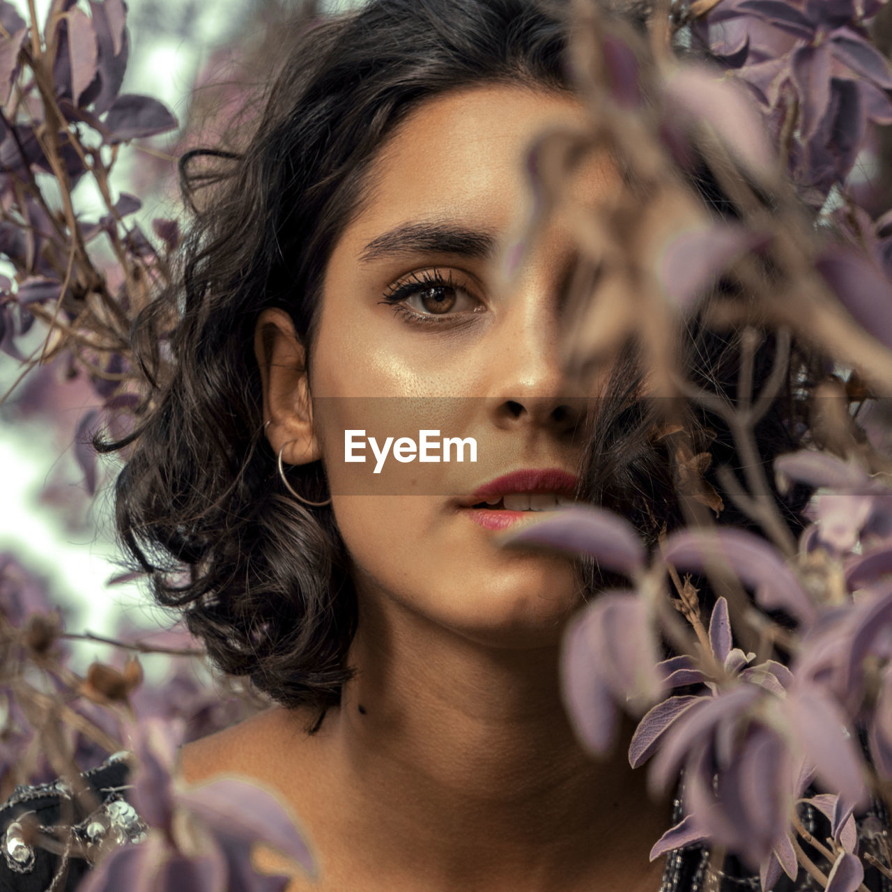 Portrait of young woman amidst plants