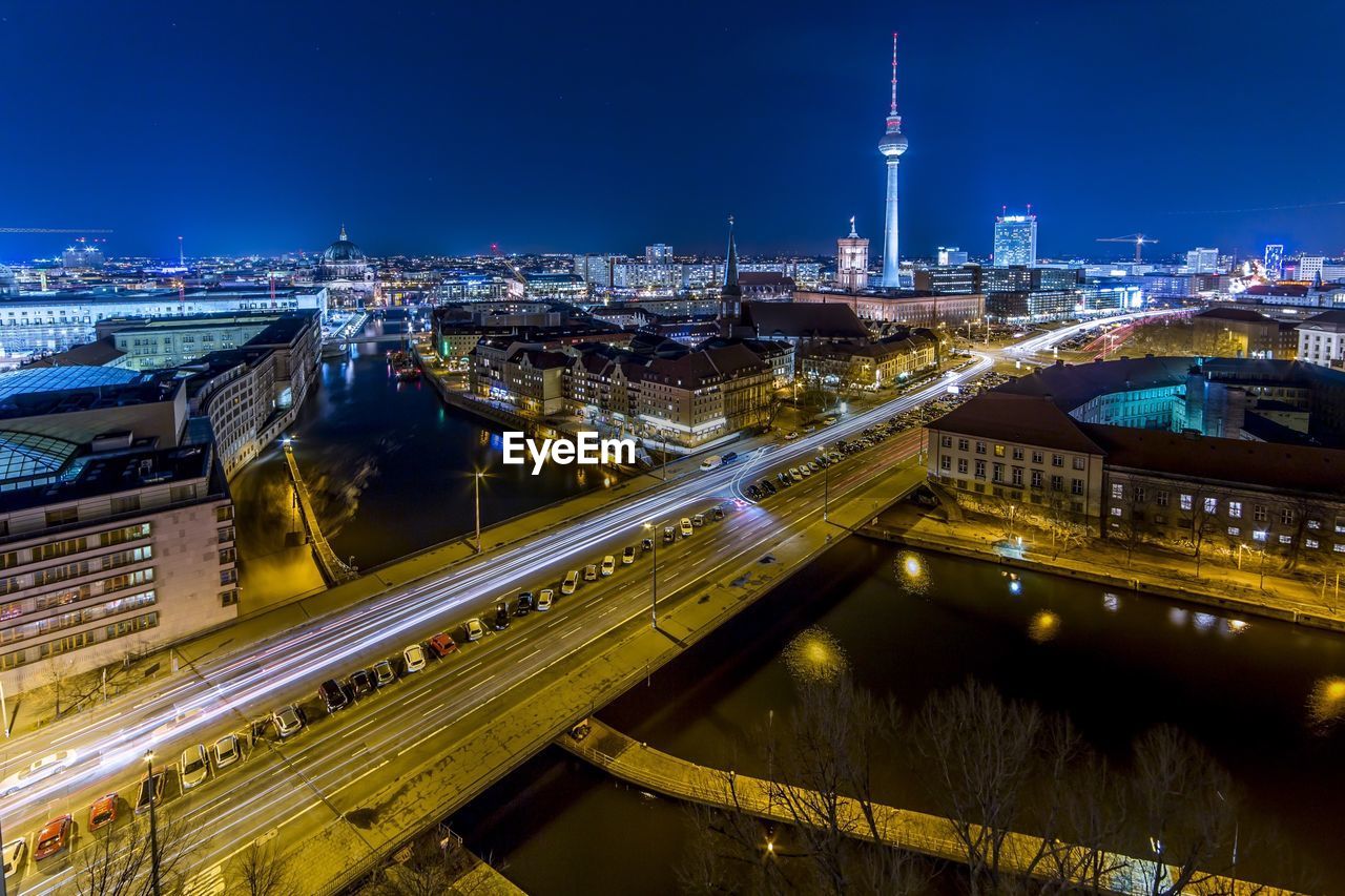 Illuminated city buildings and bridge over canal