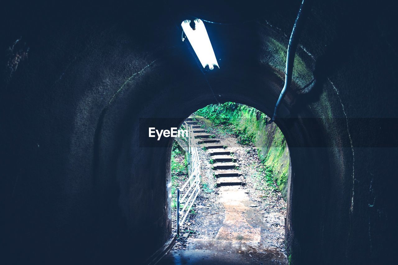 Staircase seen through illuminated tunnel