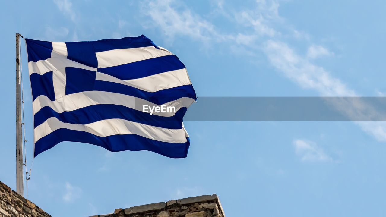 LOW ANGLE VIEW OF FLAG FLAGS AGAINST BLUE SKY