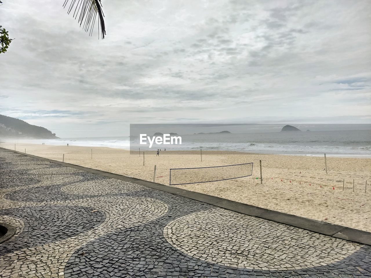 SCENIC VIEW OF BEACH AGAINST CLOUDY SKY