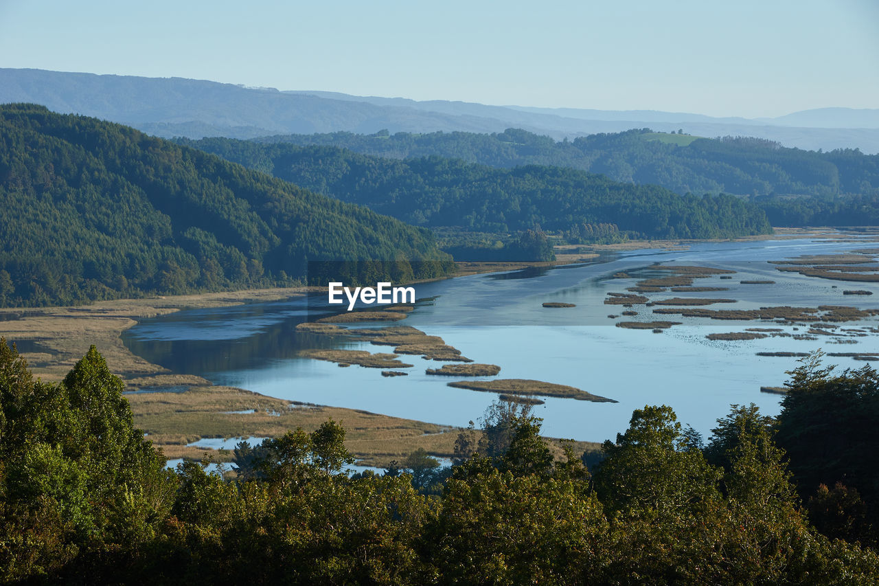 Scenic view of lake by mountains against sky