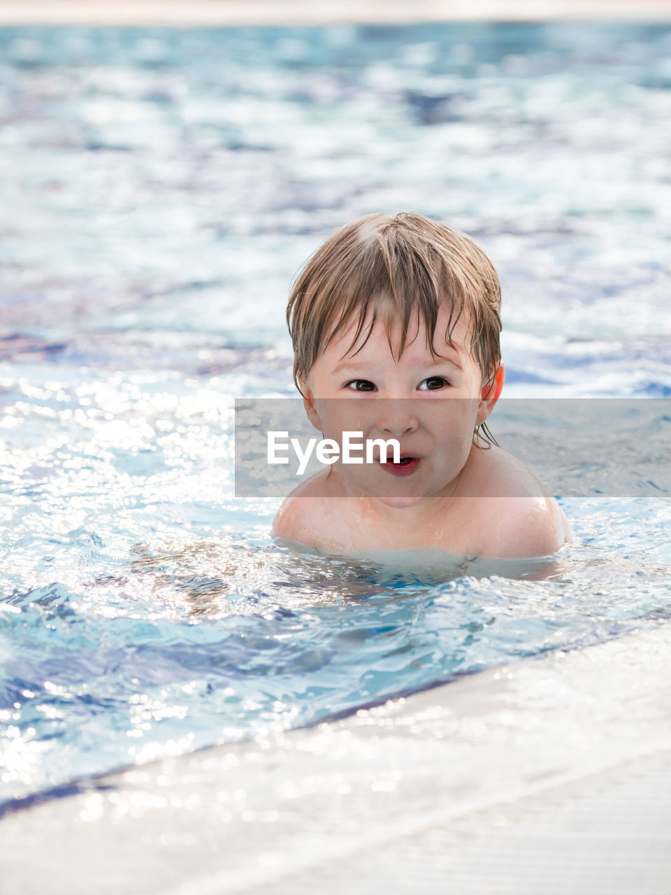 Toddler floats in paddling pool. teaching children to swim from early childhood. 