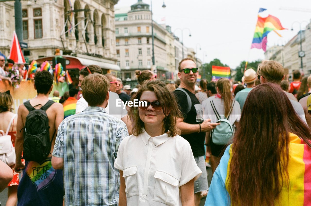 REAR VIEW OF PEOPLE STANDING IN CITY