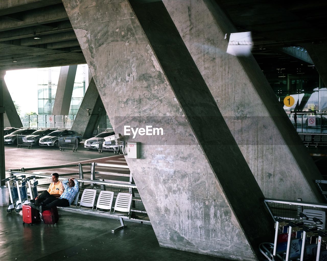 HIGH ANGLE VIEW OF PEOPLE SITTING ON SEAT IN SUBWAY