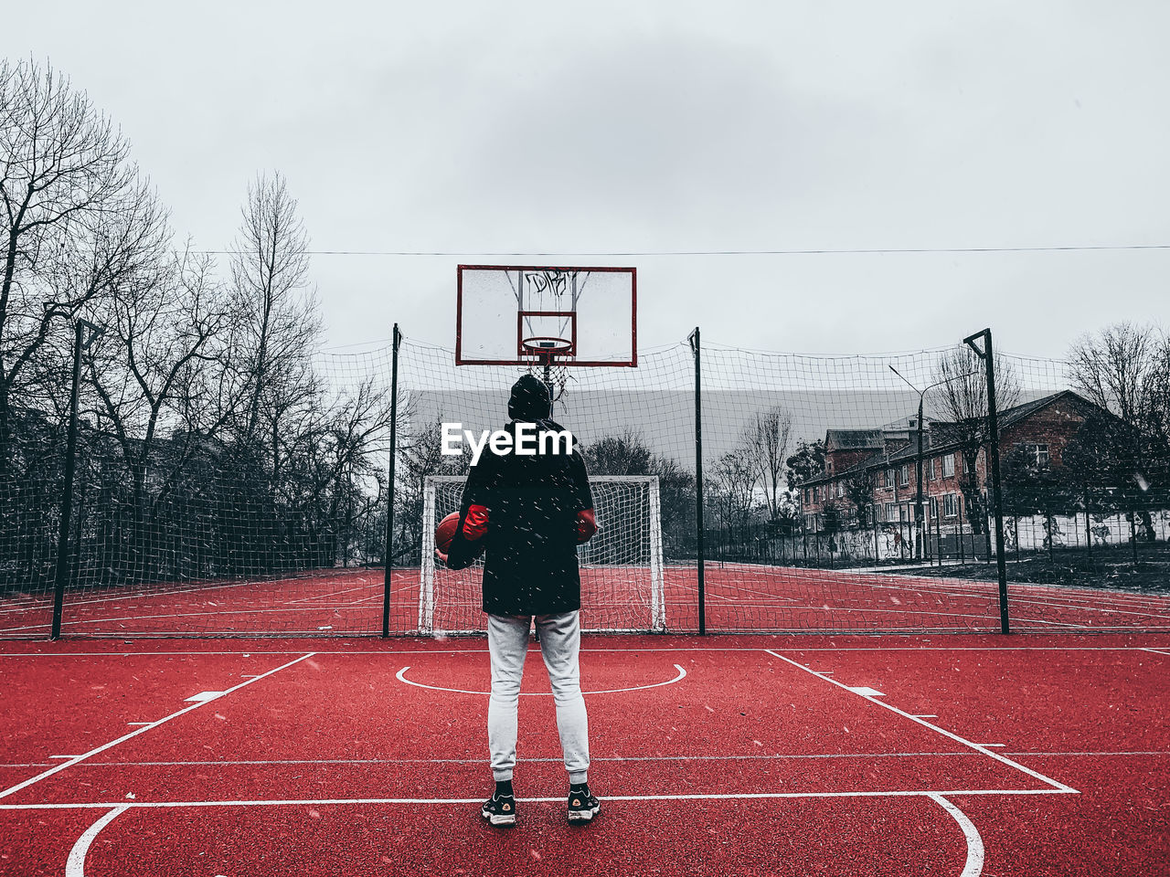 Rear view of man standing on field basketball 