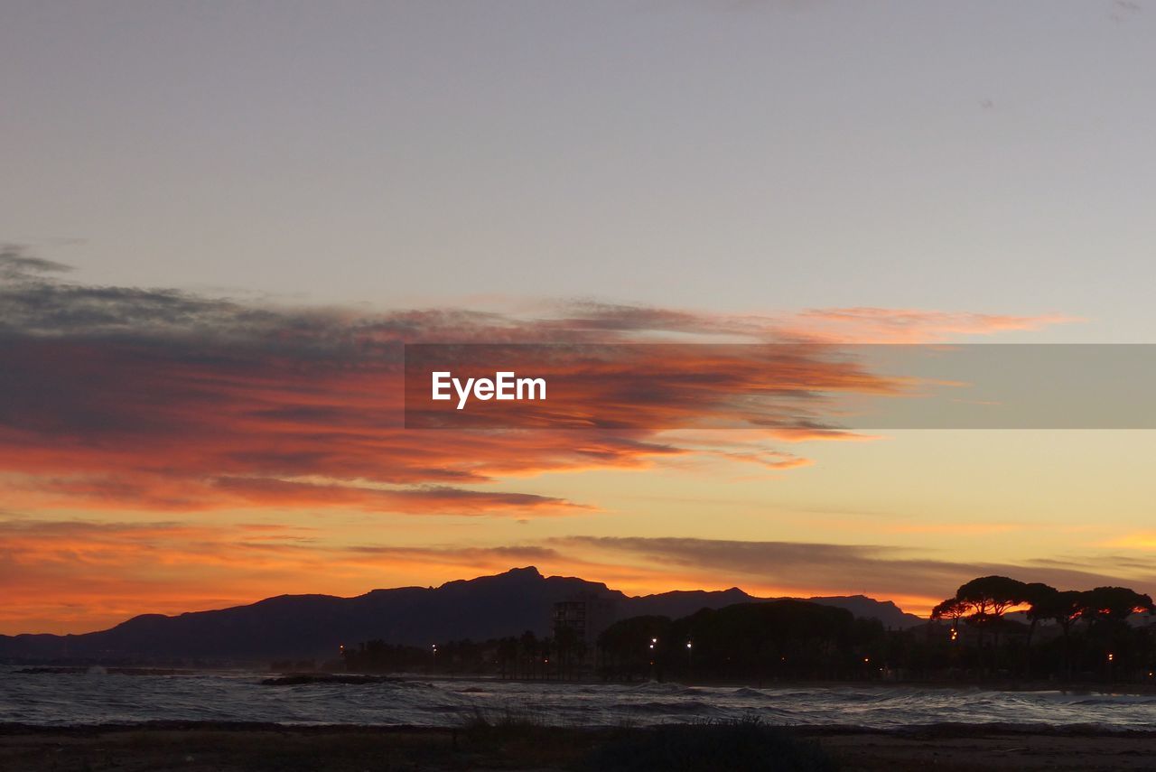 SCENIC VIEW OF SEA AGAINST SKY AT SUNSET