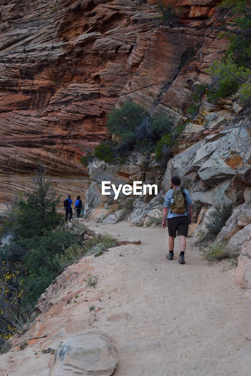 Rear view of people walking on mountain road