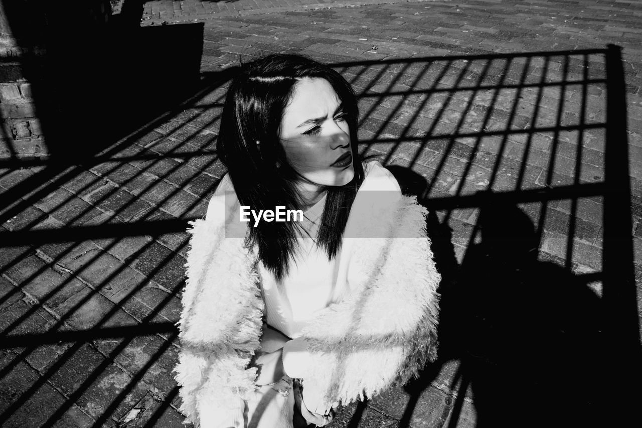 Young woman wearing fur sitting outdoors