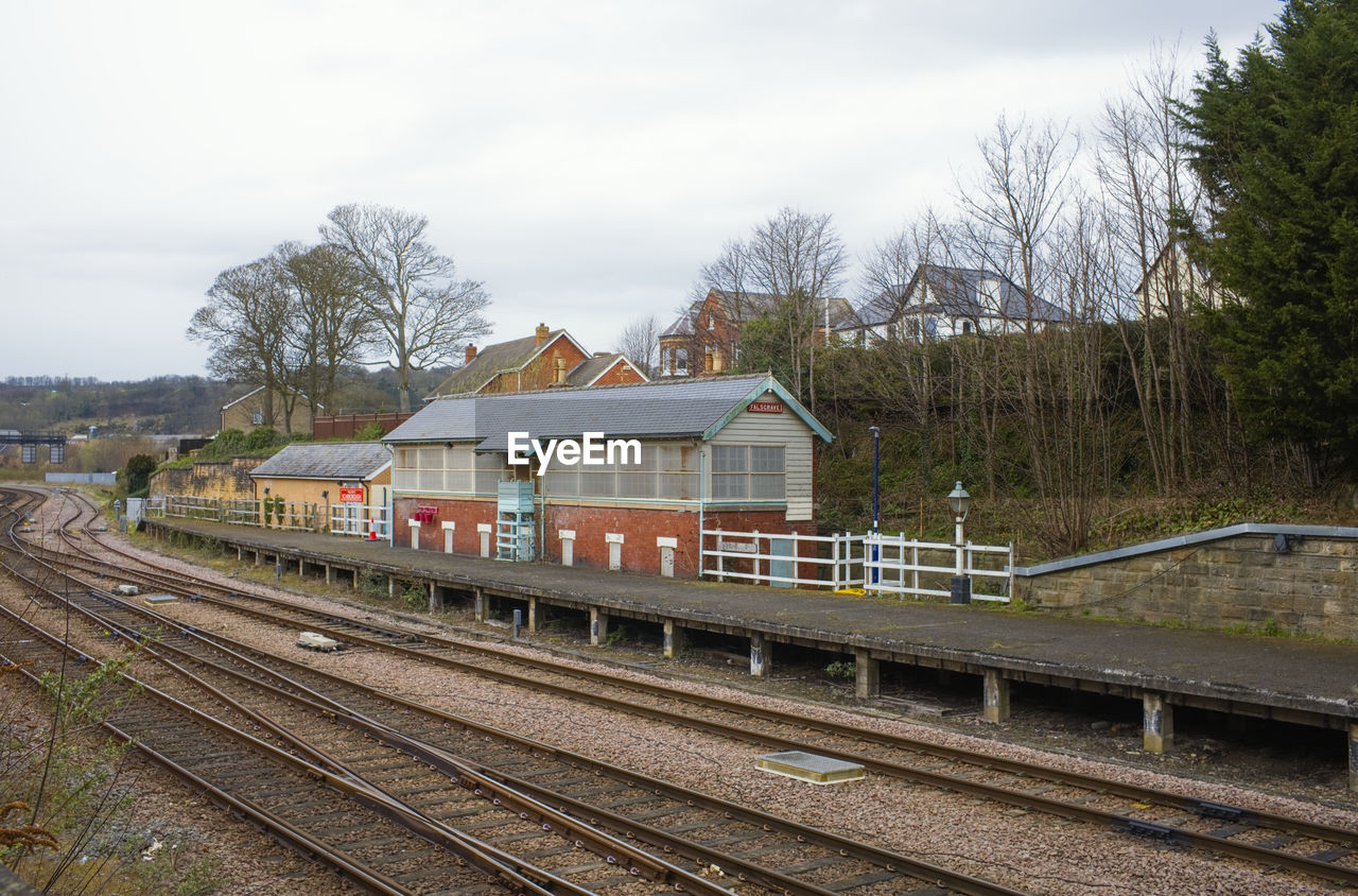 rail transportation, railroad track, track, transport, railway, transportation, architecture, train, vehicle, train station, mode of transportation, sky, built structure, public transportation, nature, tree, cloud, rolling stock, no people, building exterior, plant, railroad station, travel, day, outdoors, railroad station platform, building