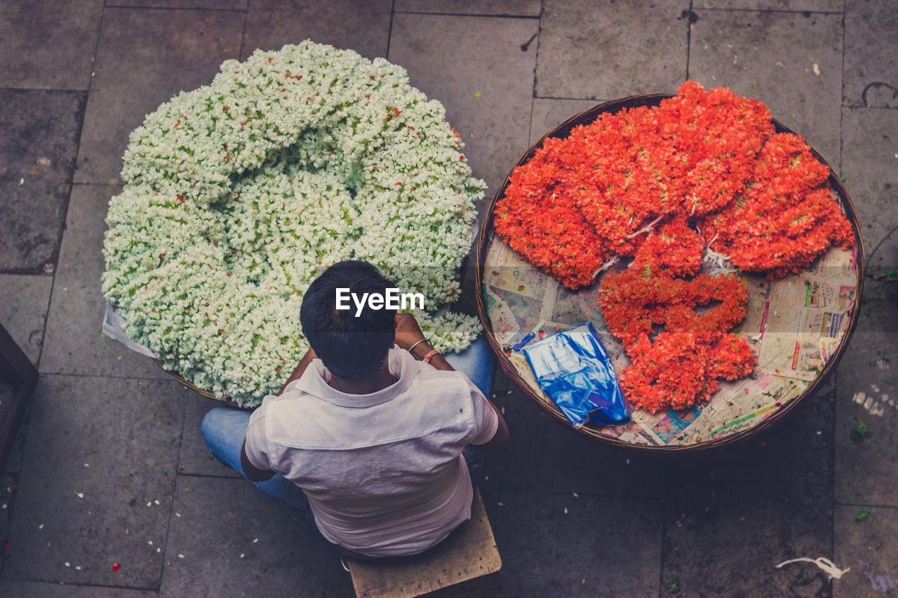 HIGH ANGLE VIEW OF MAN FOR SALE AT MARKET STALL