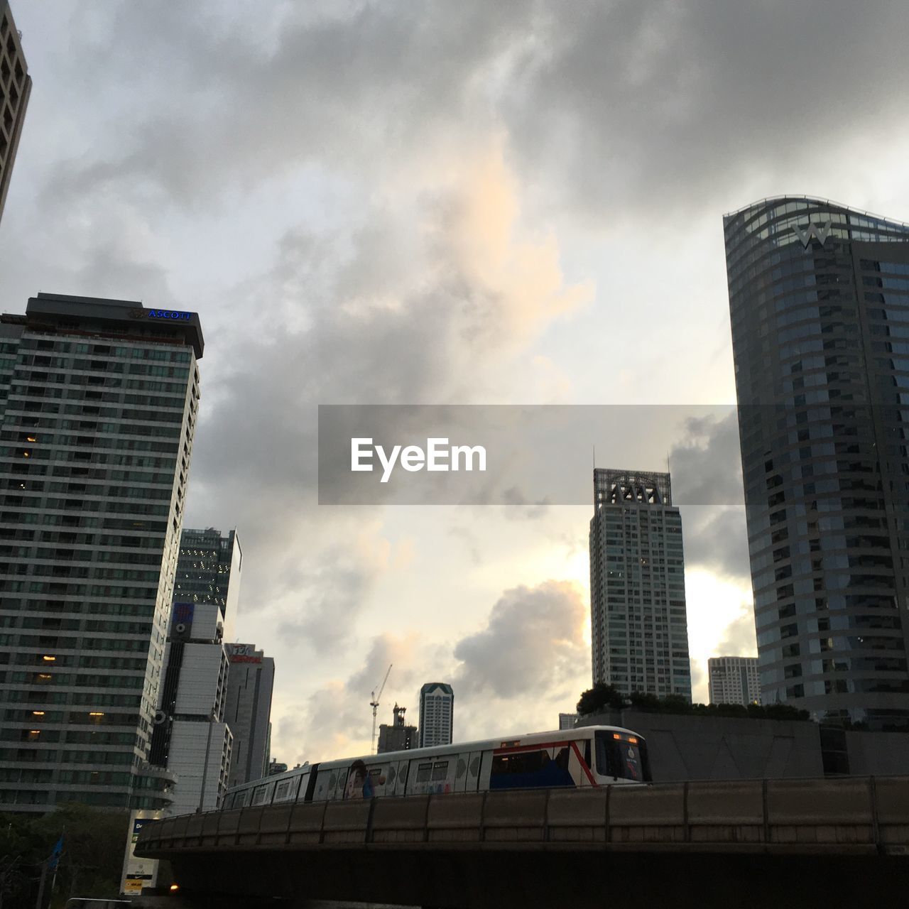 LOW ANGLE VIEW OF MODERN BUILDINGS AGAINST CLOUDY SKY