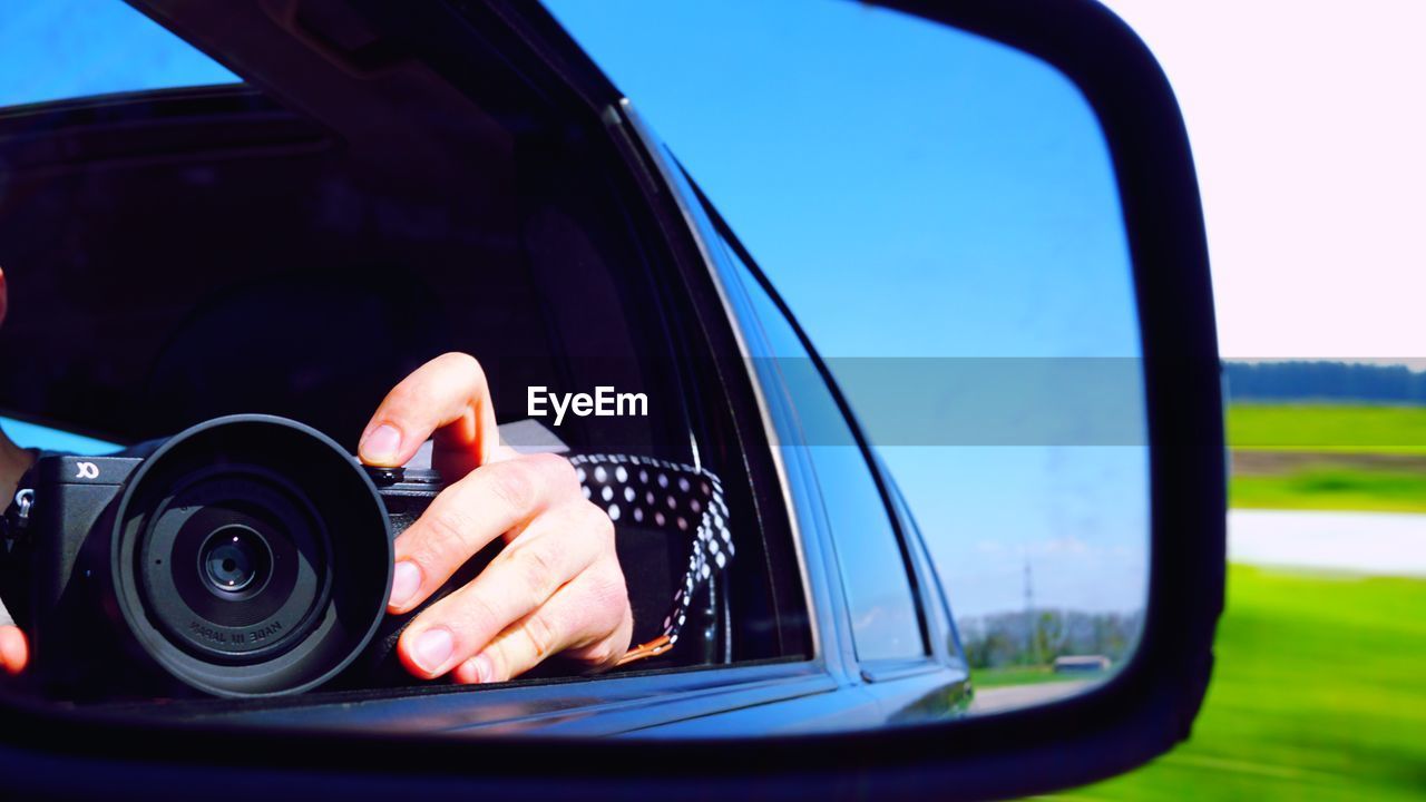 REFLECTION OF MAN HAND HOLDING CAR