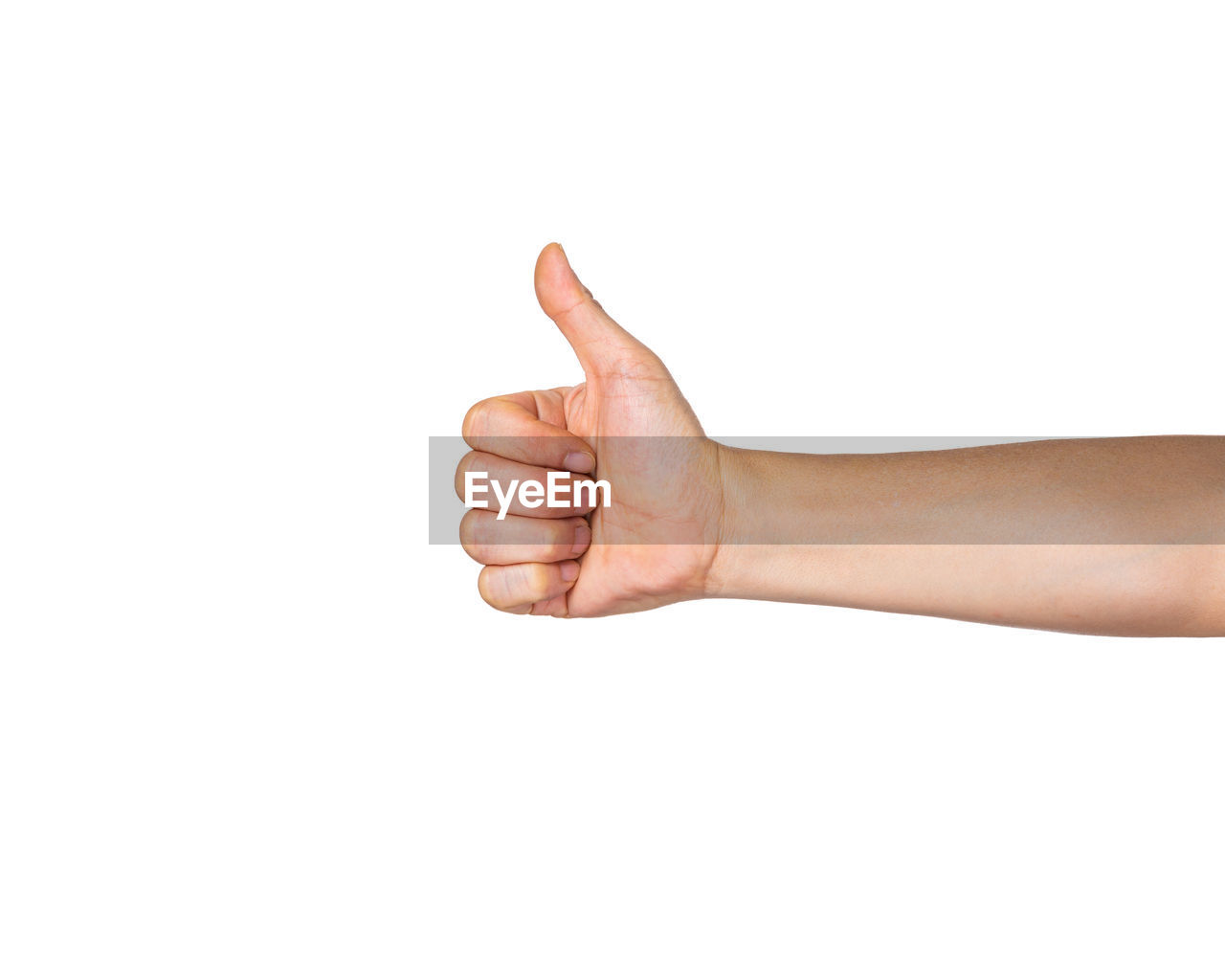 Close-up of cropped hand showing thumbs up sign against white background