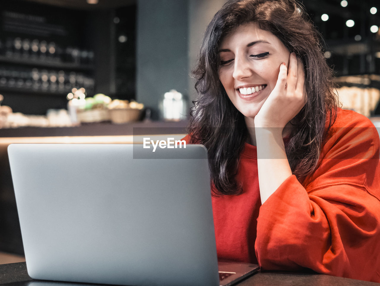 PORTRAIT OF SMILING YOUNG MAN USING LAPTOP