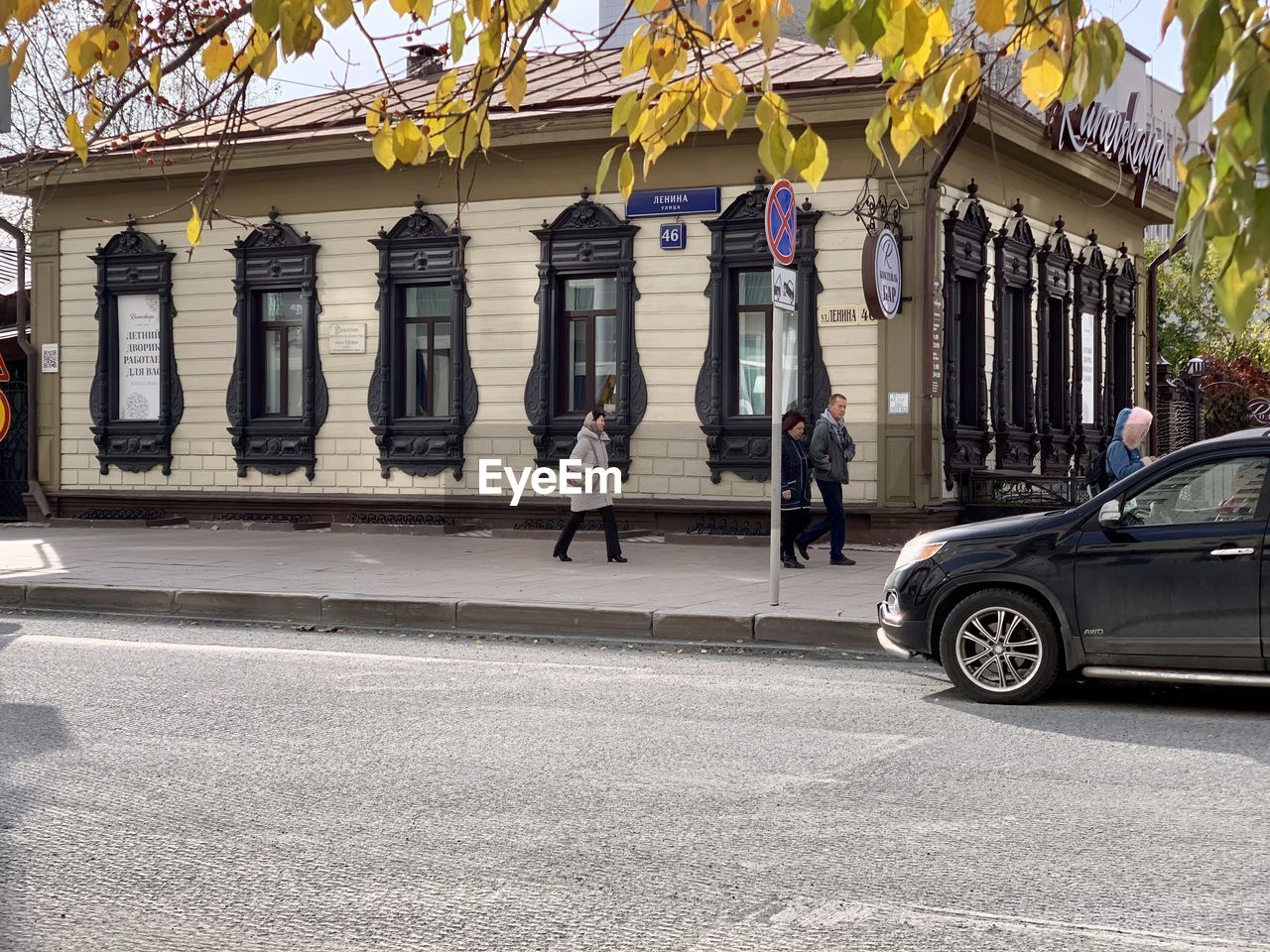 PEOPLE ON STREET AGAINST BUILDING