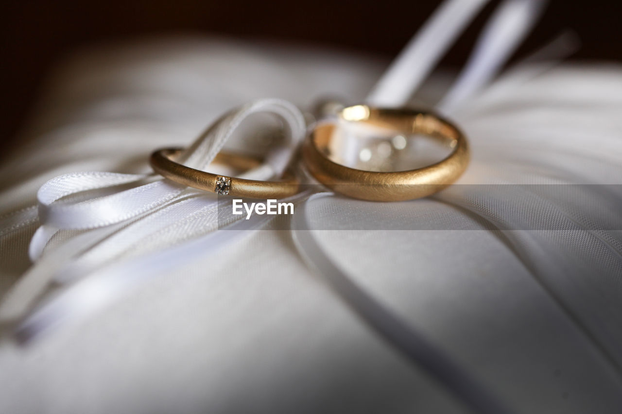 Close-up of wedding rings on pillow