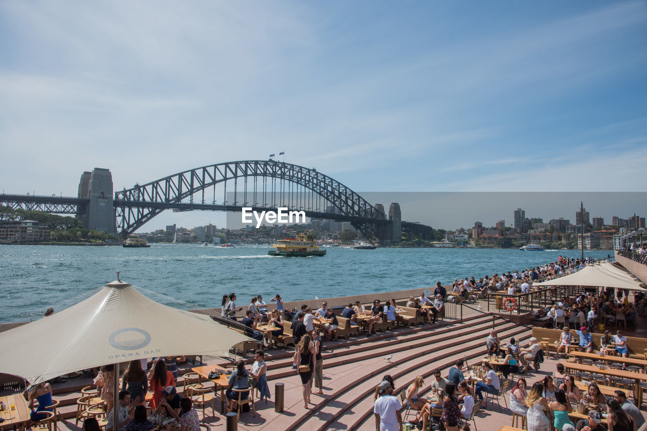 PANORAMIC VIEW OF PEOPLE AT SEASIDE