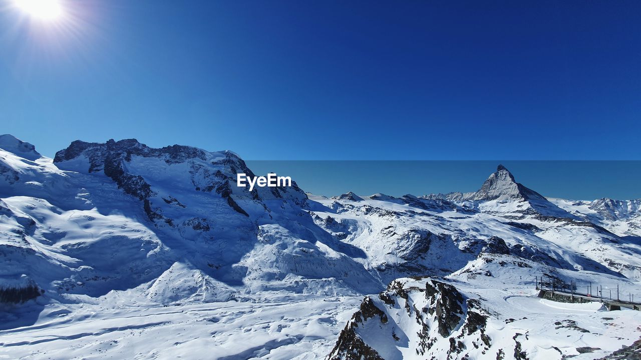 SNOWCAPPED MOUNTAINS AGAINST BLUE SKY