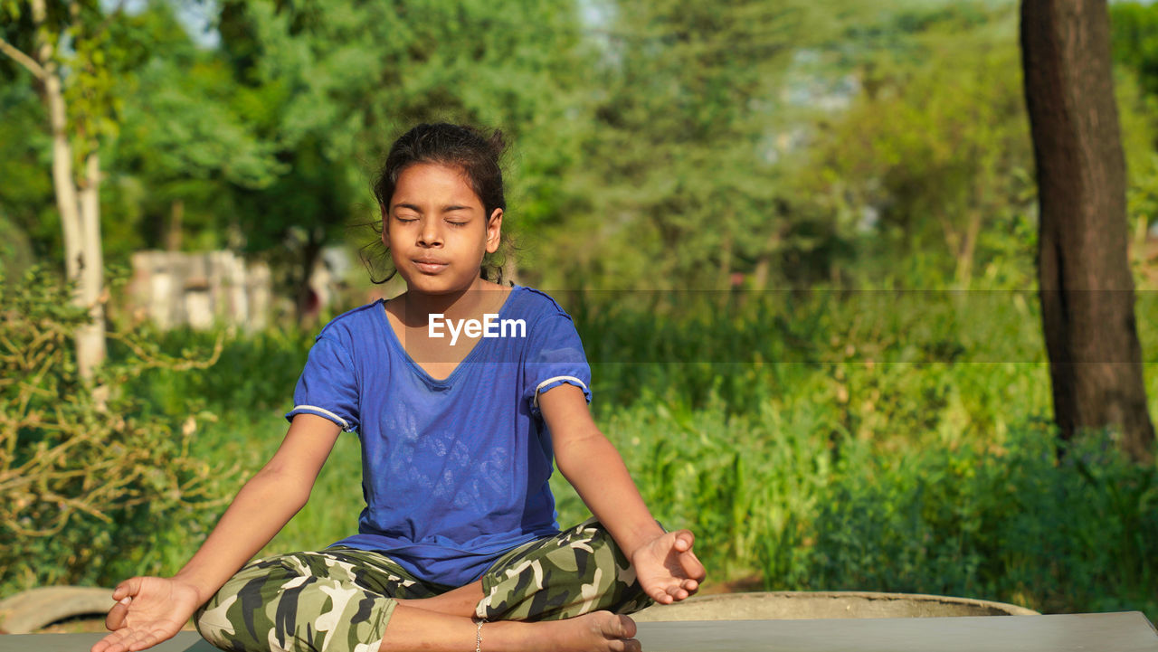 Indian child doing exercise on platform outdoors. healthy lifestyle. yoga girl.