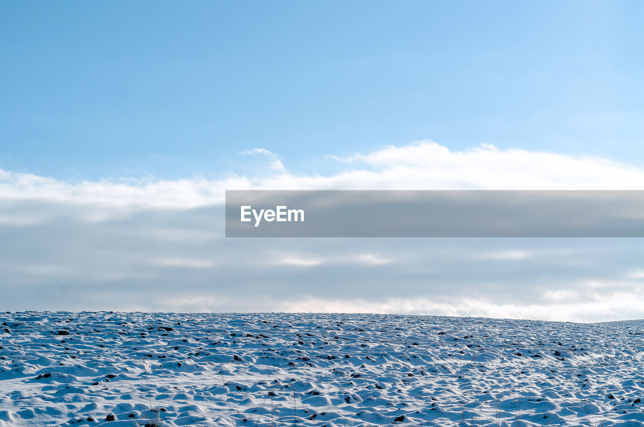 Winter snowy field under blue sky. seasonal concept.