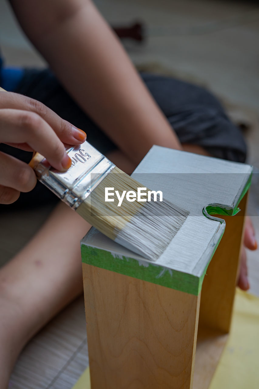 Midsection of person holding paper on table