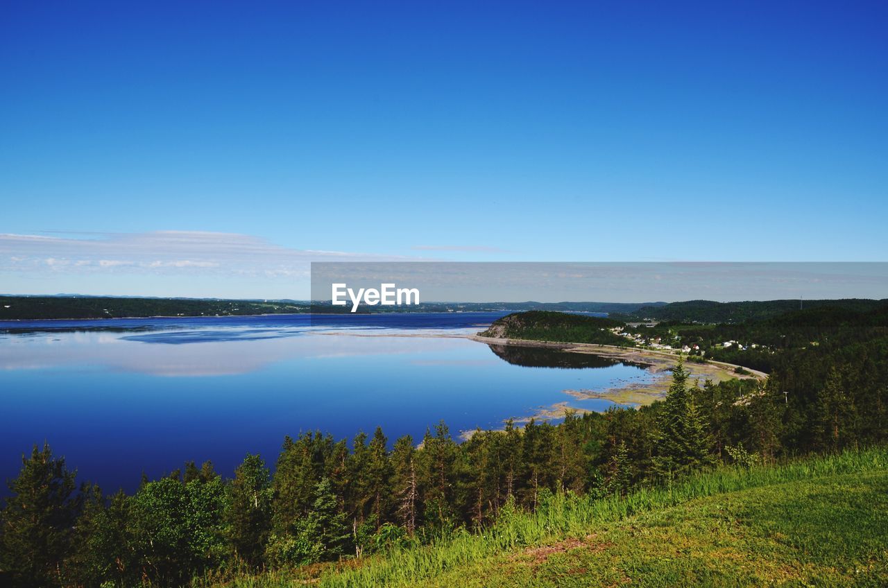 Scenic view of lake against clear blue sky