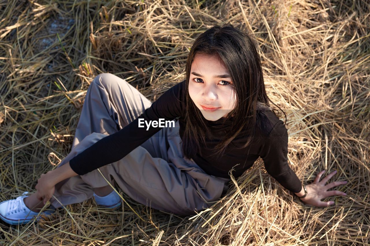 Portrait of teenage girl sitting on field