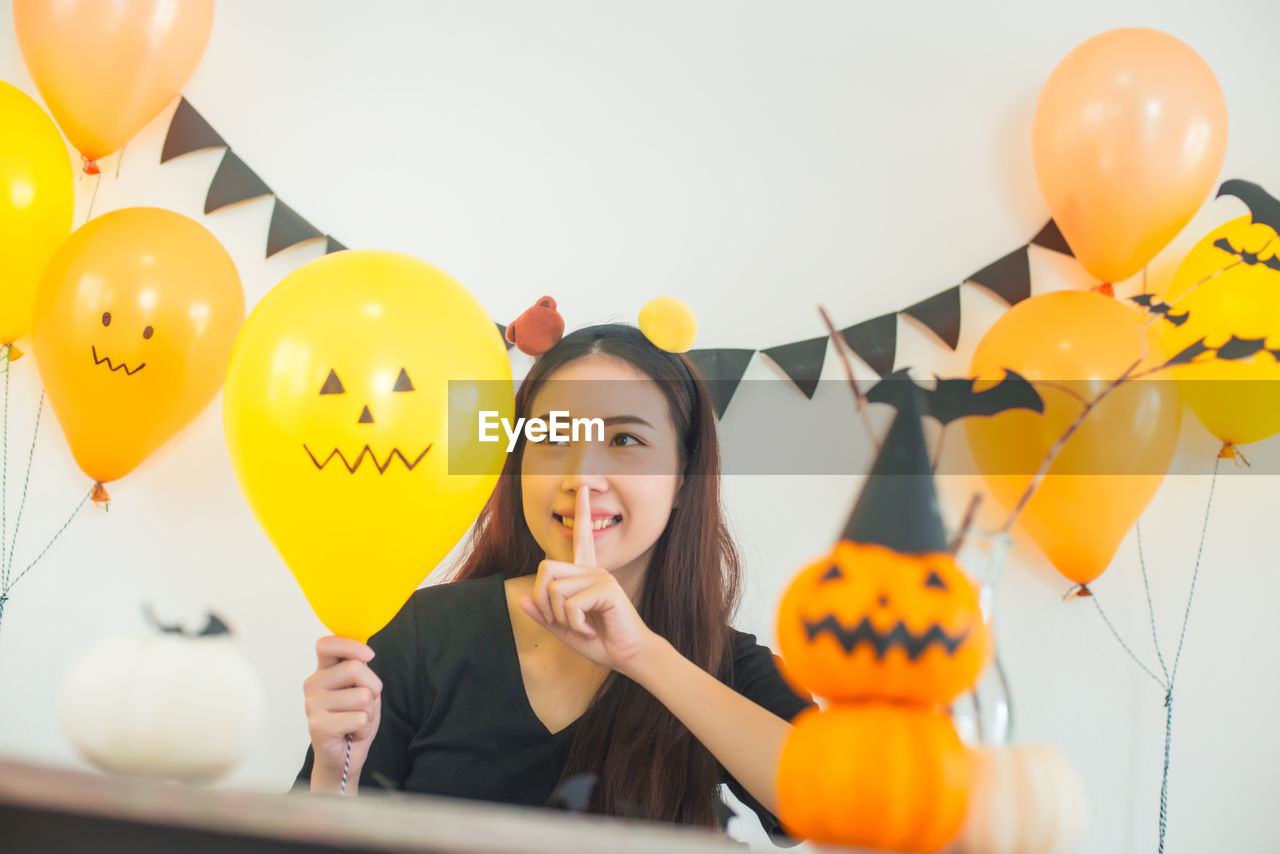 Woman looking at balloon during halloween celebration