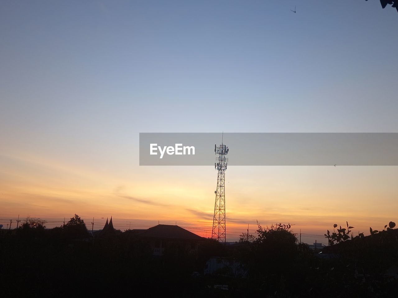 sky, sunset, silhouette, horizon, afterglow, technology, communications tower, architecture, dawn, nature, evening, built structure, tower, scenics - nature, sun, landscape, beauty in nature, environment, no people, tree, orange color, sunlight, cloud, communication, broadcasting, outdoors, copy space, city, tranquility, travel destinations, electricity, plant, building exterior, tranquil scene, building, land, business finance and industry, global communications, idyllic