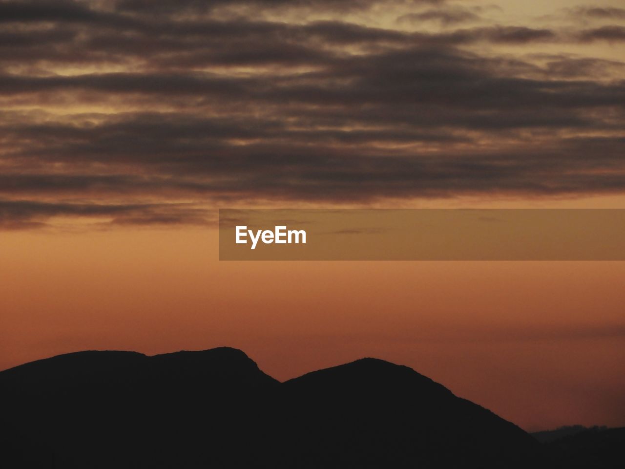 SCENIC VIEW OF DRAMATIC SKY OVER SILHOUETTE MOUNTAINS