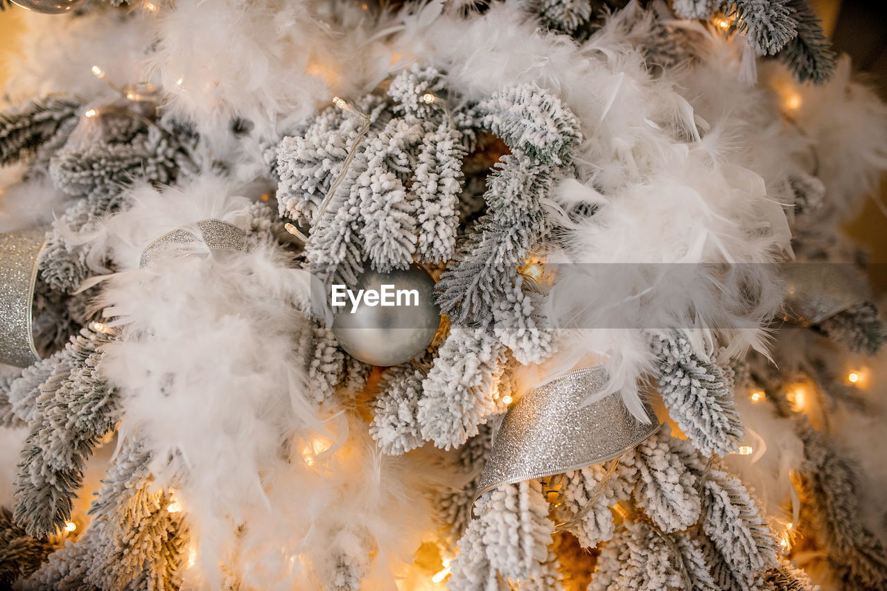 Close-up of illuminated christmas tree in snow