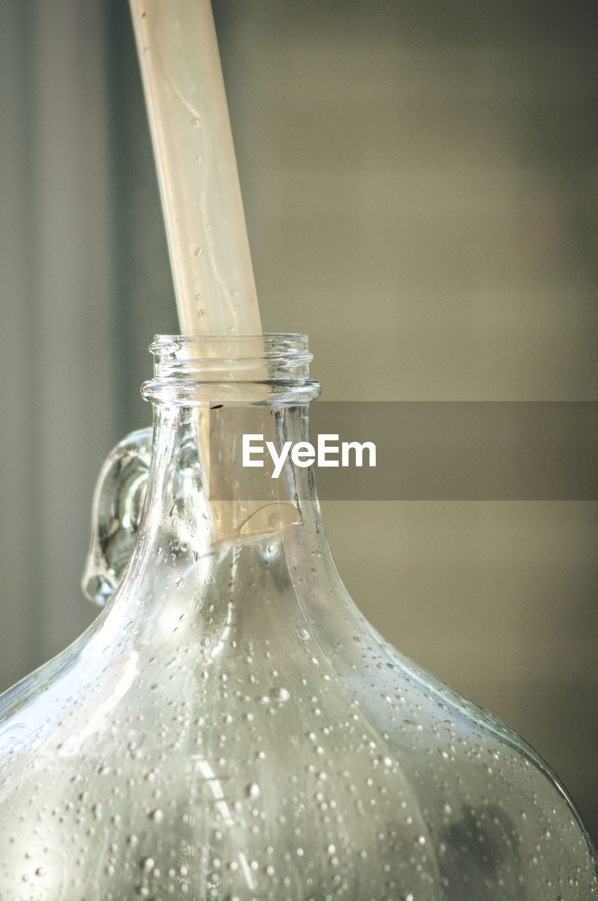 Close-up of glass bottle with drinking straw