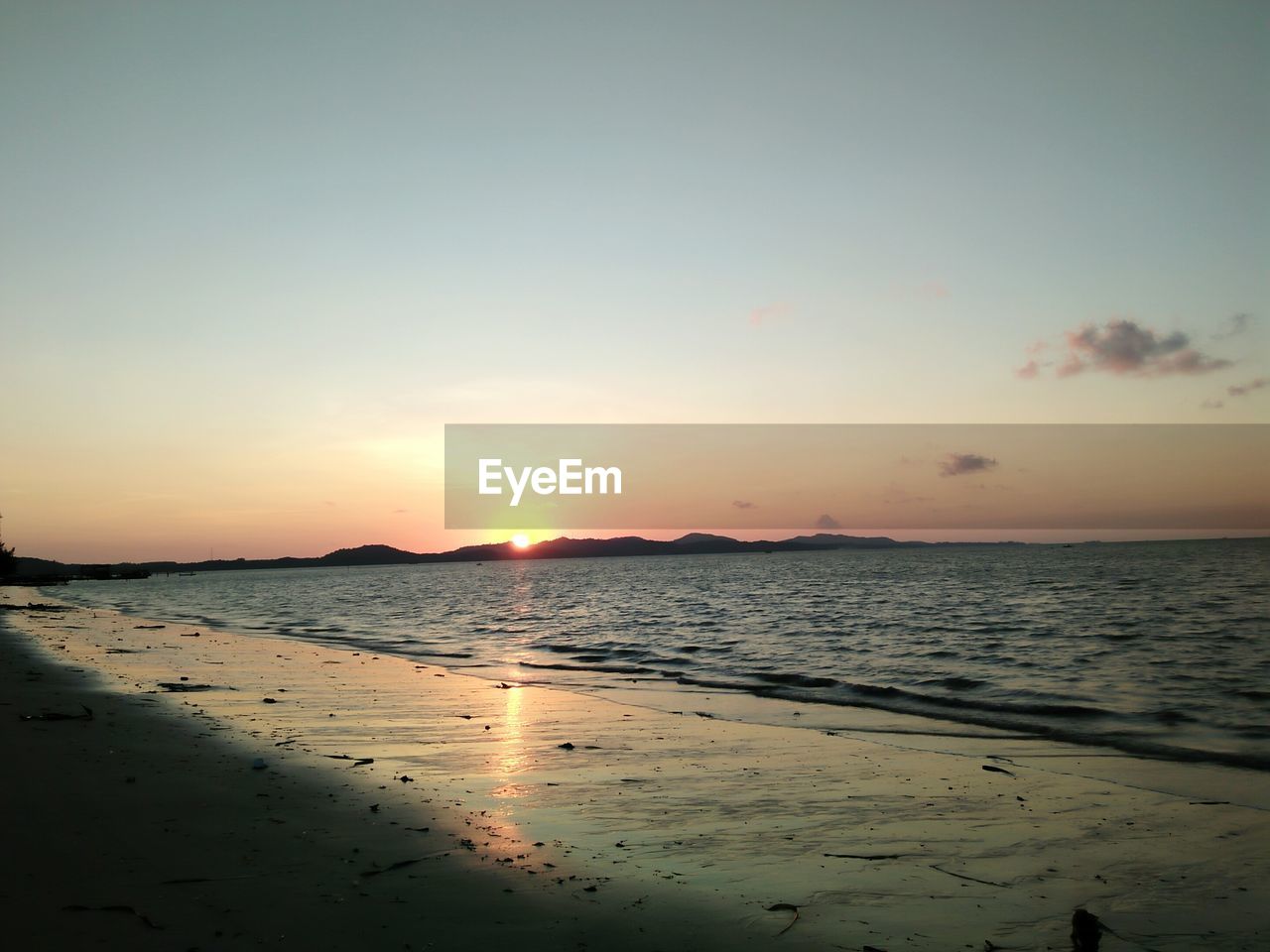 SCENIC VIEW OF BEACH DURING SUNSET