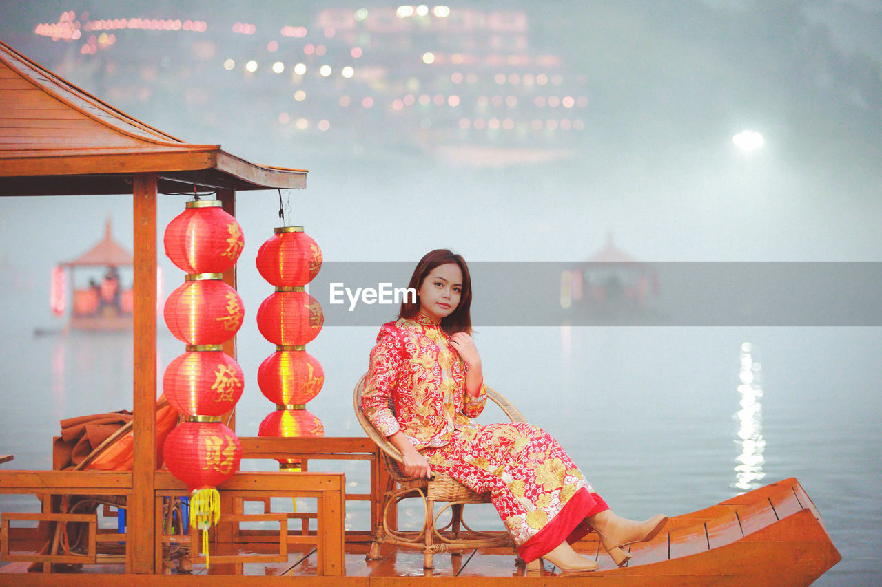 Asian woman wearing cheongsam traditional red dress on chinese new year travel.