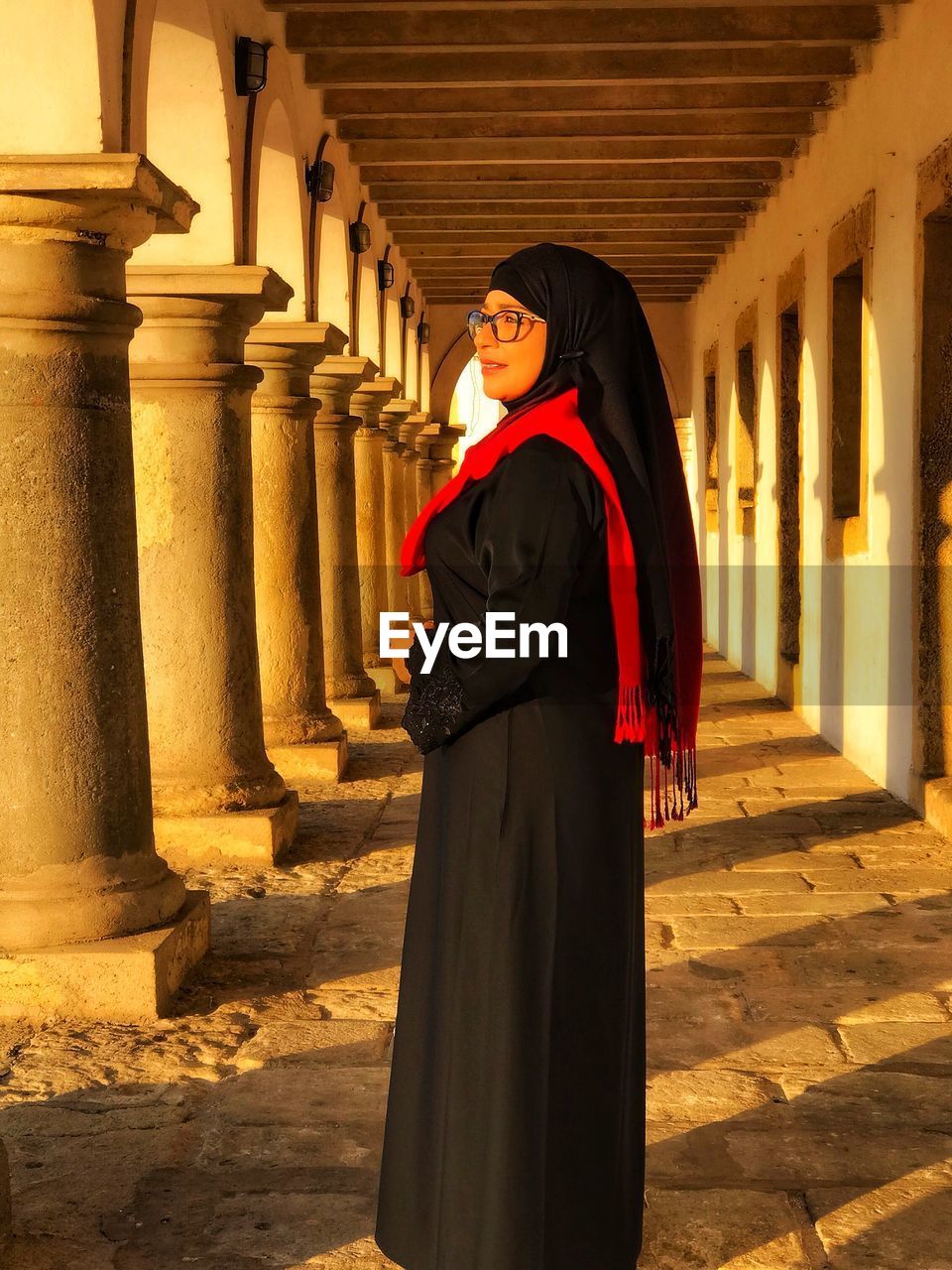 WOMAN STANDING BY HISTORIC BUILDING