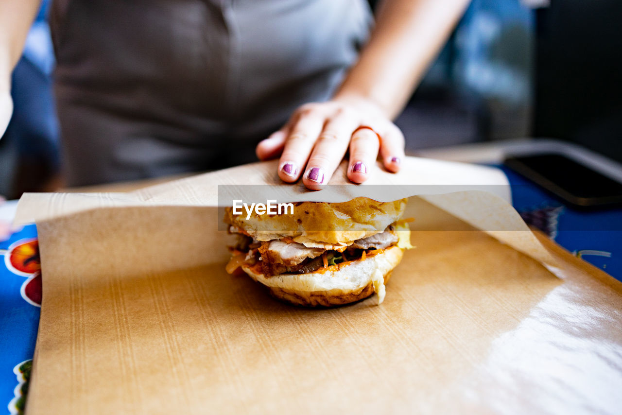 Midsection of man holding burger