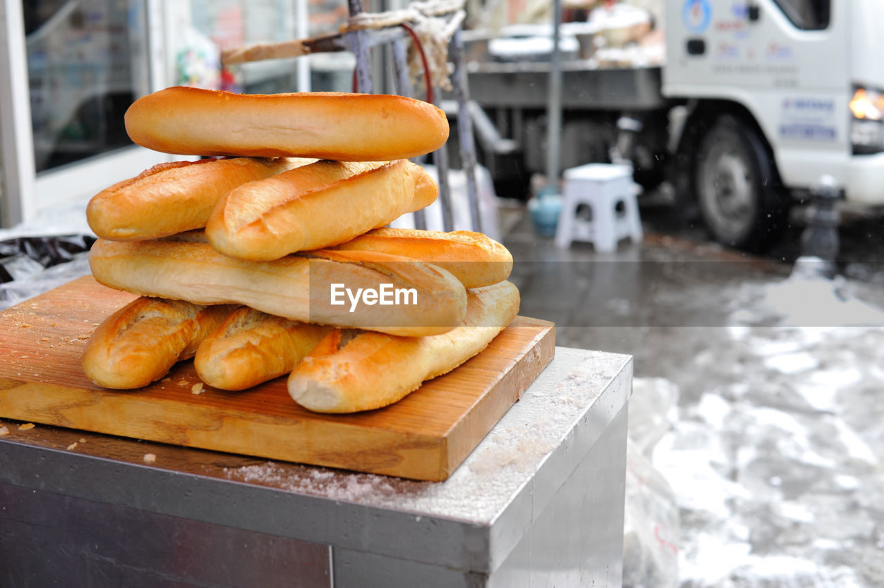 Close-up of bread on cutting board against truck