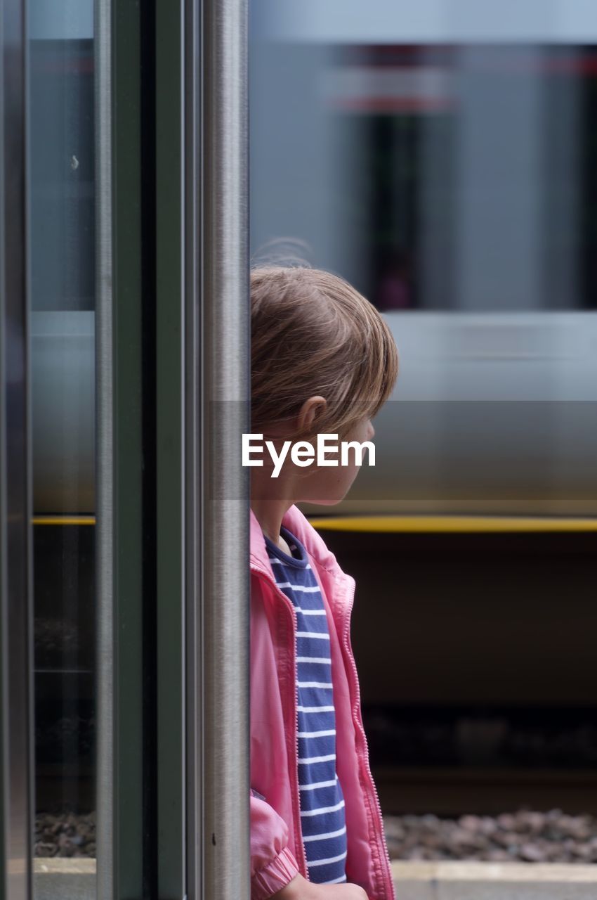 Rear view of girl looking at a train window