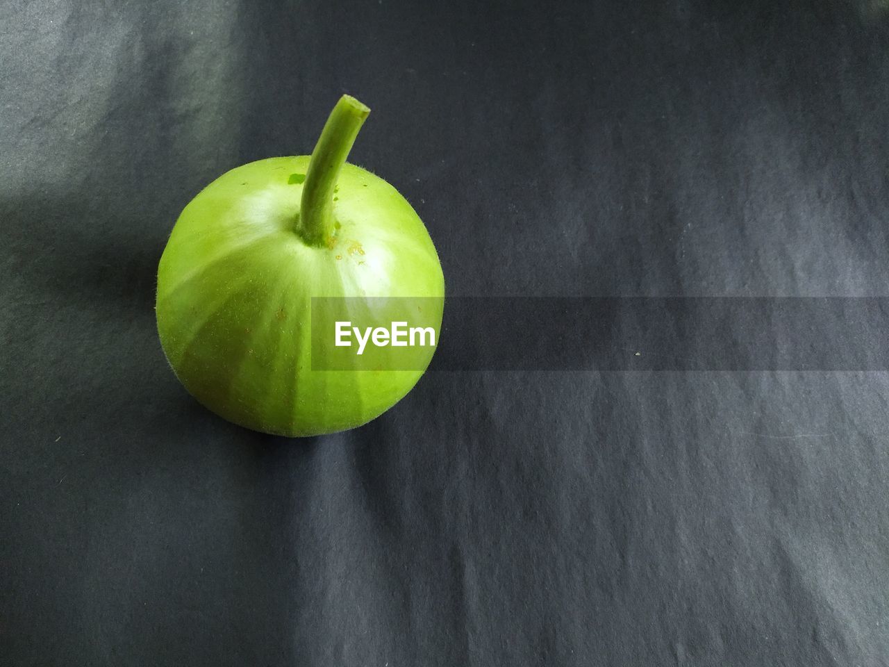 HIGH ANGLE VIEW OF APPLE ON TABLE AGAINST WHITE BACKGROUND