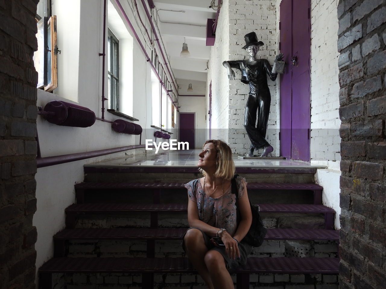 Woman looking up while sitting on steps